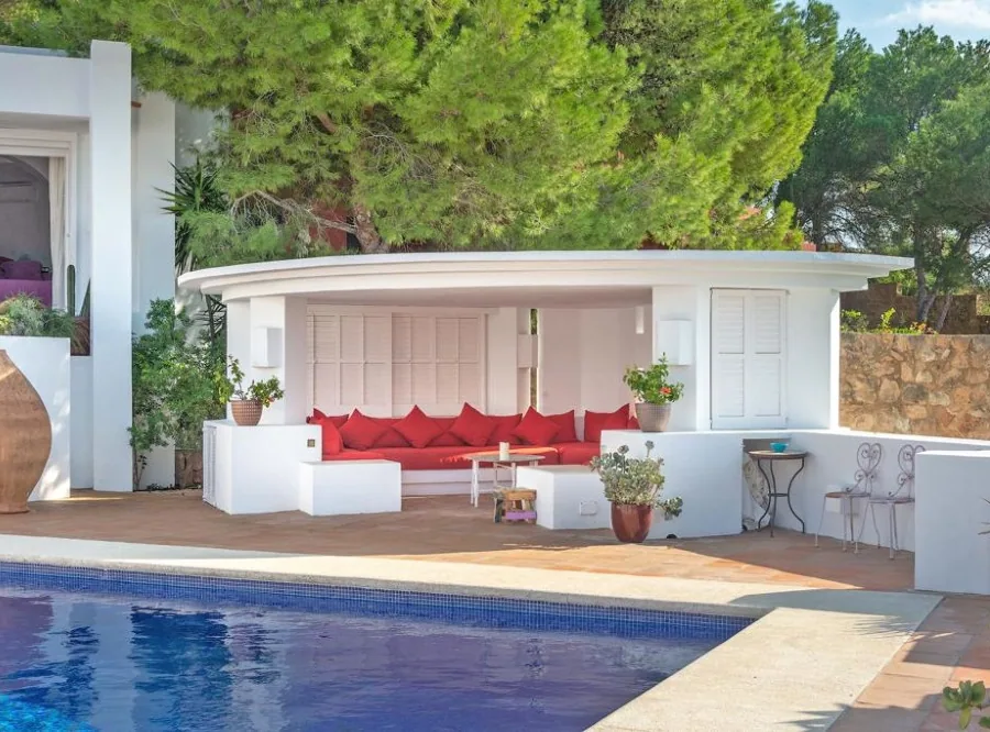 Poolside chill-out seating area beside a villa pool